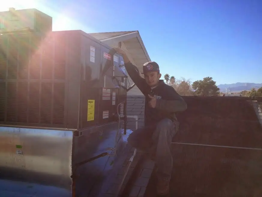 HVAC technician performing HVAC Inspection on a rooftop unit in Ellettsville